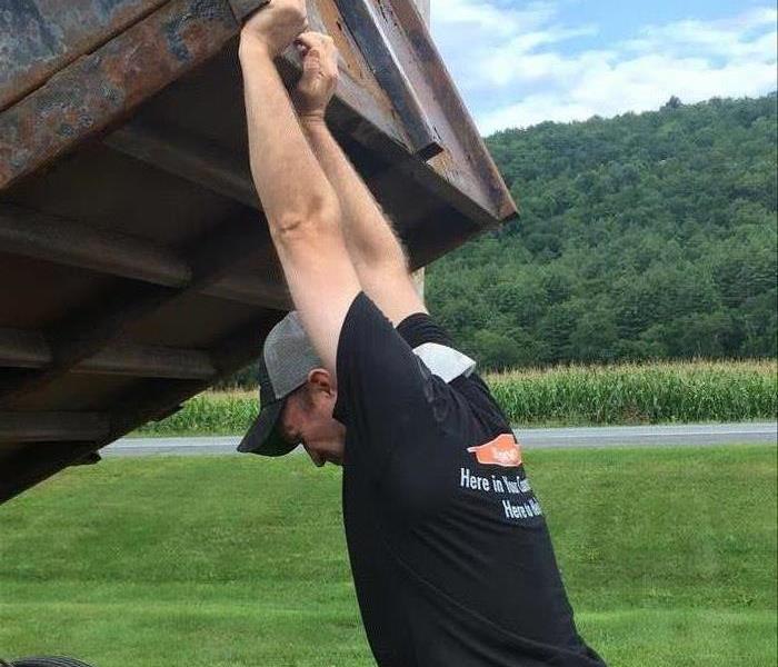Tony in Vermont acting strong lifting a trailer